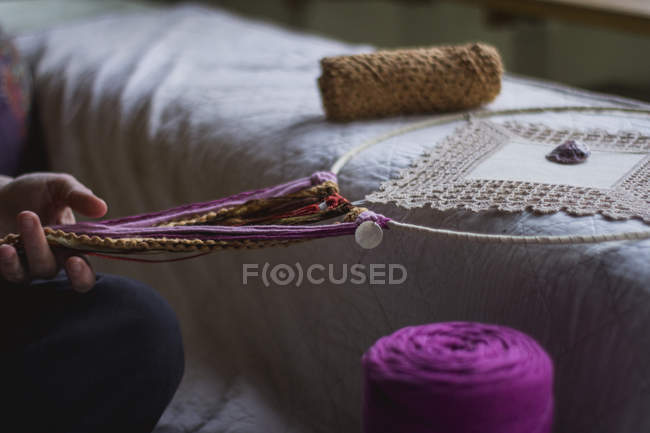Обрізане зображення жінки, що створює мрійника ручної роботи з довгими нитками, що проводять час у будинку — стокове фото