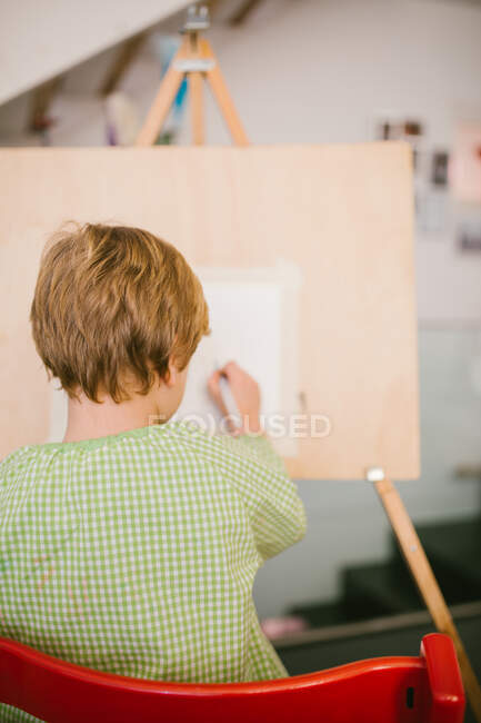 Kind zeichnet zu Hause auf Leinwand — Stockfoto