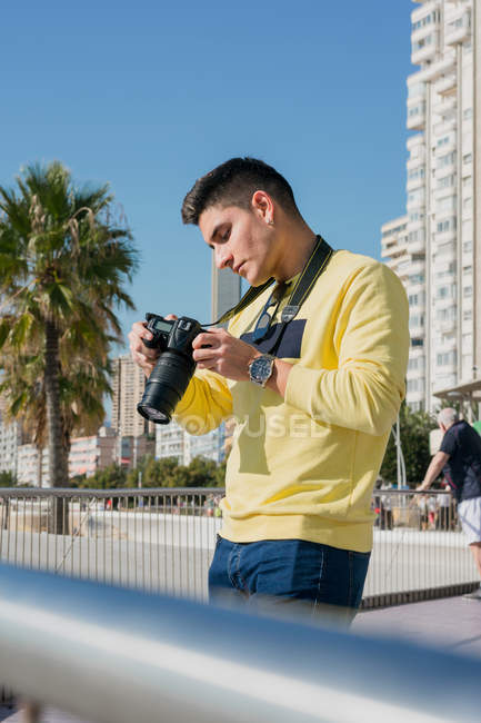 Creativo joven fotógrafo de tiro en la costa - foto de stock