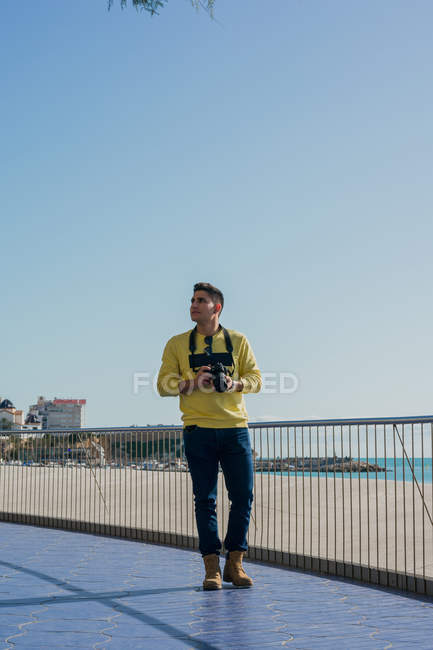 Jovem fotógrafo criativo atirando em beira-mar — Fotografia de Stock