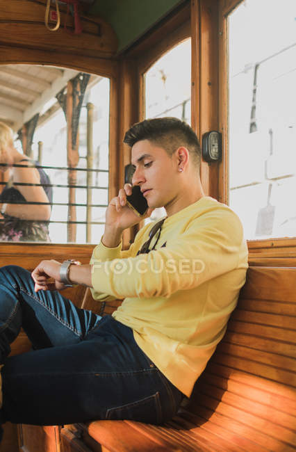 Homem falando ao telefone enquanto cavalga no trem — Fotografia de Stock