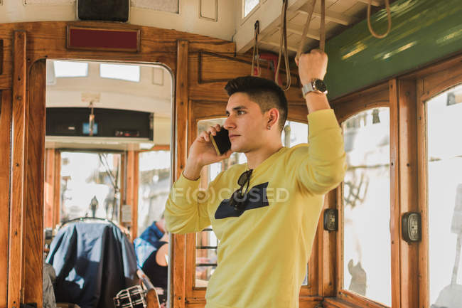 Uomo che parla al telefono mentre guida in treno — Foto stock