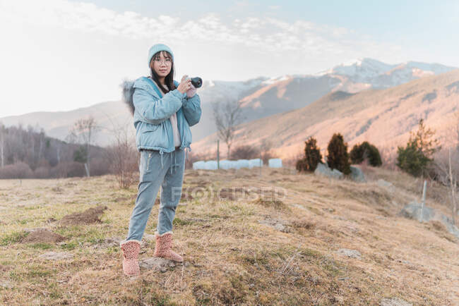 Woman taking picture with camera of landscape — Stock Photo