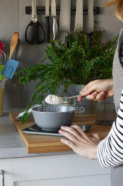 Anonymous housewife preparing dough in kitchen — Stock Photo