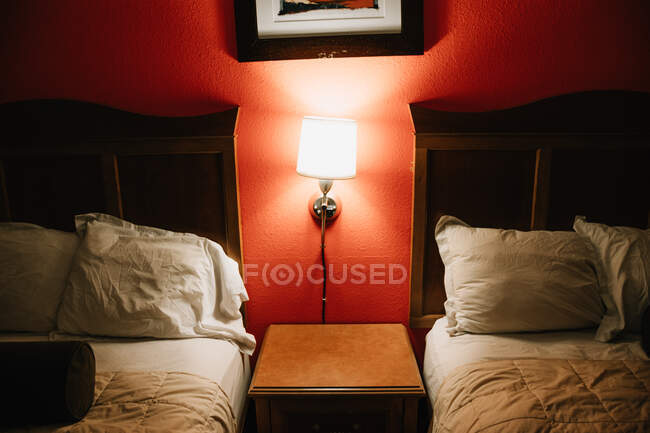 Cozy and modern bedroom with pillows and lamp and red wallpaper in hotel in Venice beach — Stock Photo
