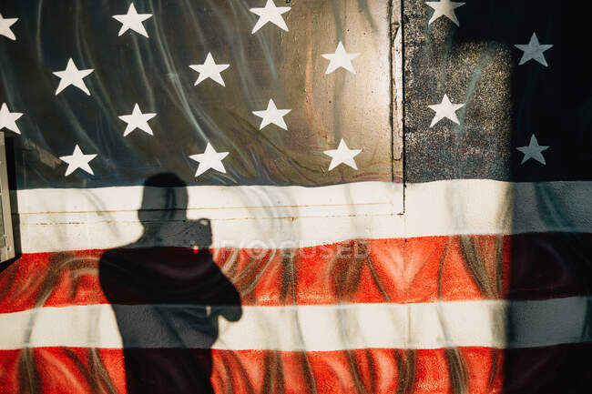Maschio con macchina fotografica che fotografa graffiti con bandiera degli Stati Uniti d'America sul muro che viaggiano a Venezia spiaggia — Foto stock