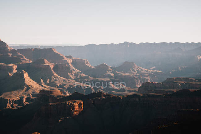 Вид на большой каньон со скалами и горами на восходе солнца в США — стоковое фото
