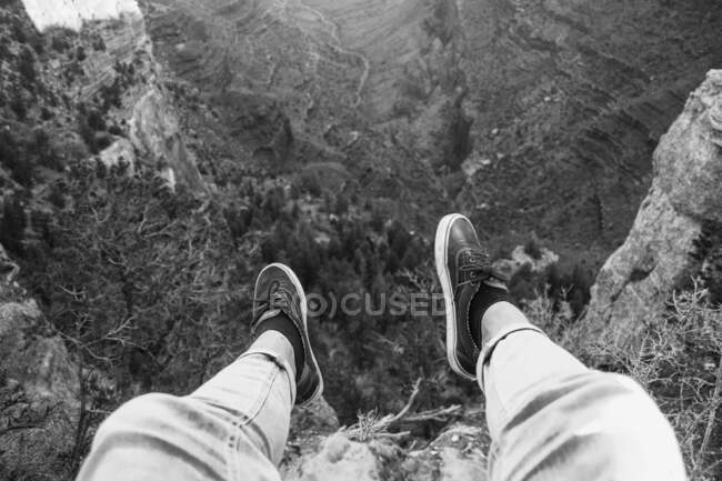 From above of faceless guy in casual wear sitting on top of rock in canyon of USA — Stock Photo