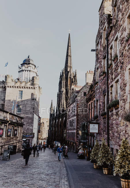 Old dark tower located amidst aged houses against gray overcast sky on town street in Edinburgh, Scotland, UK — Stock Photo