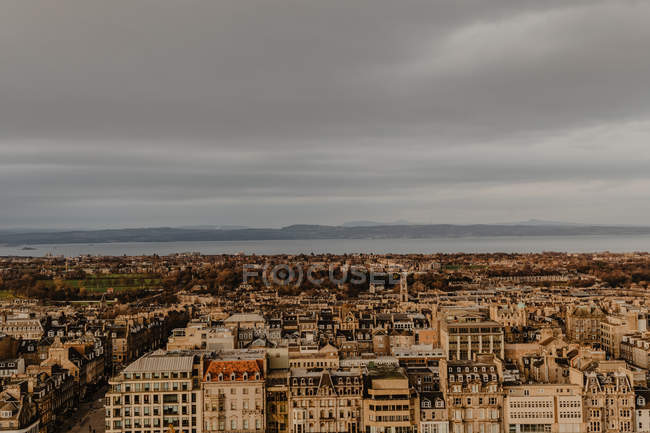 Зверху повітряний вид на історичний район старого прибережного міста проти моря і безхмарне сіре небо — стокове фото