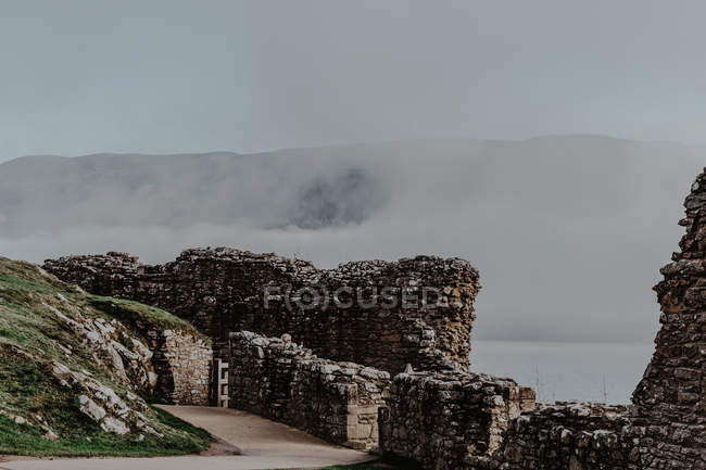 Вид зі зруйнованих будівельних стін туманних гір і пагорбів з туманом в похмурий день — стокове фото