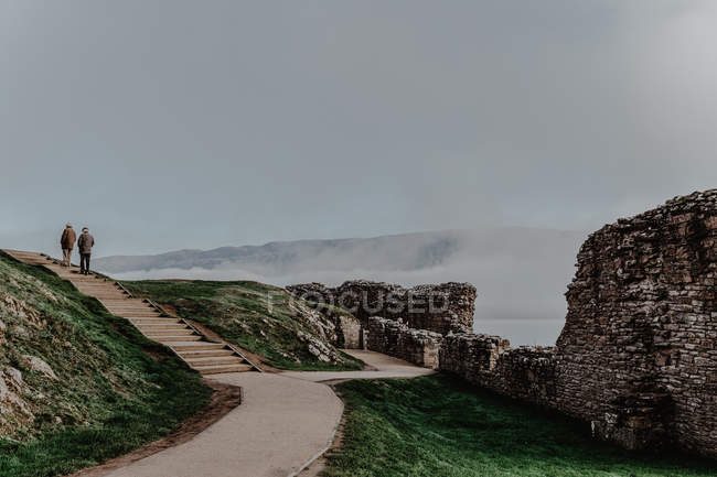 Viaggiatori che camminano su scale in pietra di castello in rovina esplorando antico castello durante il giorno nuvoloso, Edimburgo, Scozia, Regno Unito — Foto stock