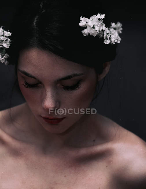 Sensual gorgeous young woman with flowers on head — Stock Photo