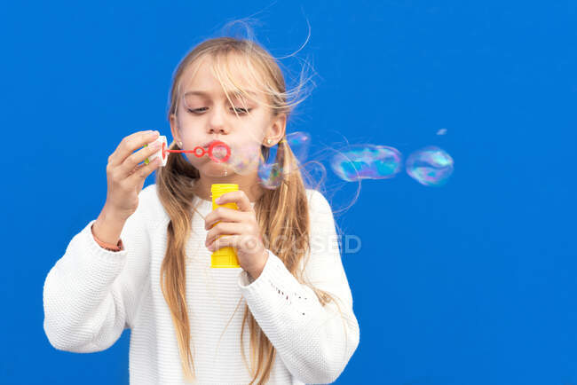 Funny girl blowing soap bubbles — Stock Photo