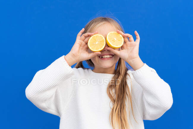 Chica positiva divirtiéndose con rodajas de limón - foto de stock