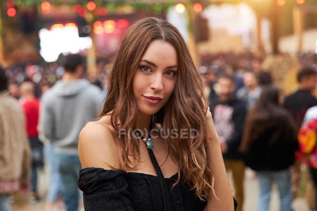 Long haired tender beautiful woman thoughtfully looking at camera in bright day in park at festival — Stock Photo