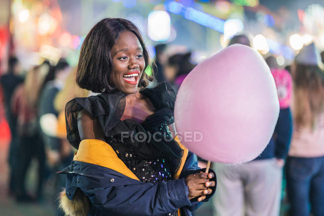 Весела афроамериканська жінка з бавовняними цукерками. — стокове фото