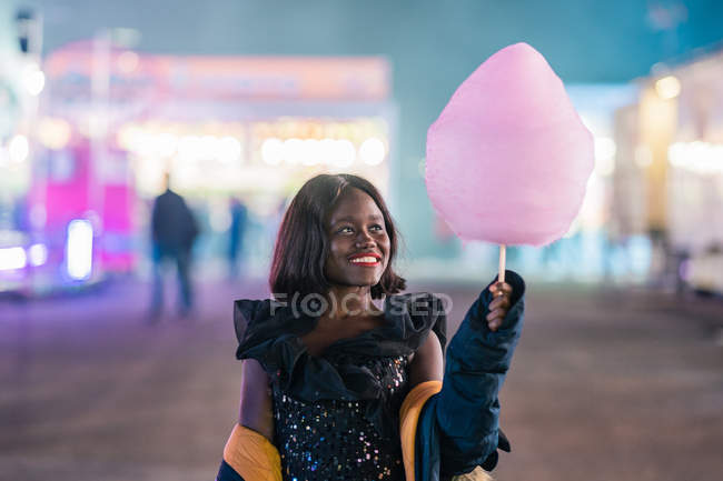 Mulher afro-americana alegre com algodão doce — Fotografia de Stock