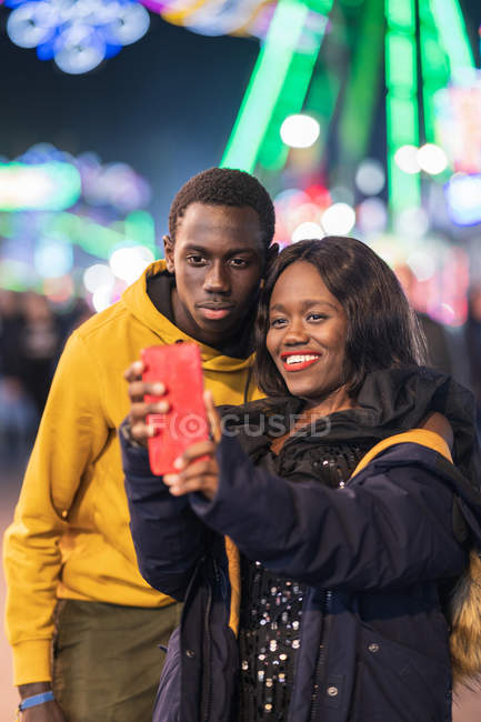 Casal preto tomando selfie no parque de diversões — Fotografia de Stock