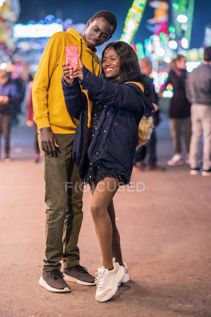 Casal preto tomando selfie no parque de diversões — Fotografia de Stock