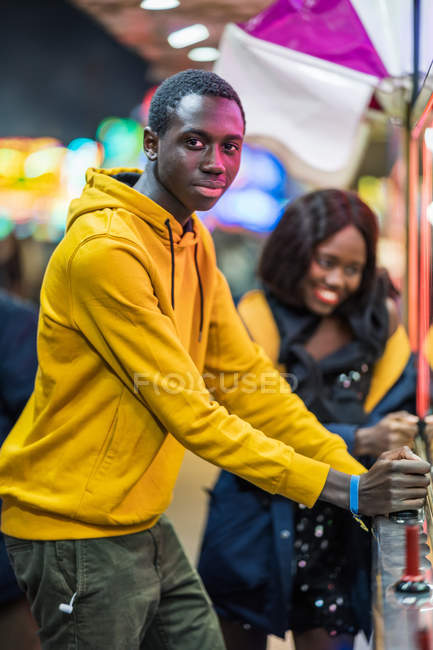 Homme noir jouant grue à griffe pour petite amie — Photo de stock