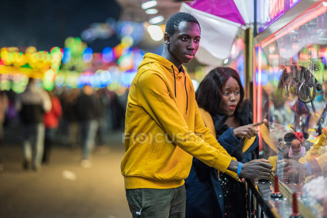 Homme noir jouant grue à griffe pour petite amie — Photo de stock