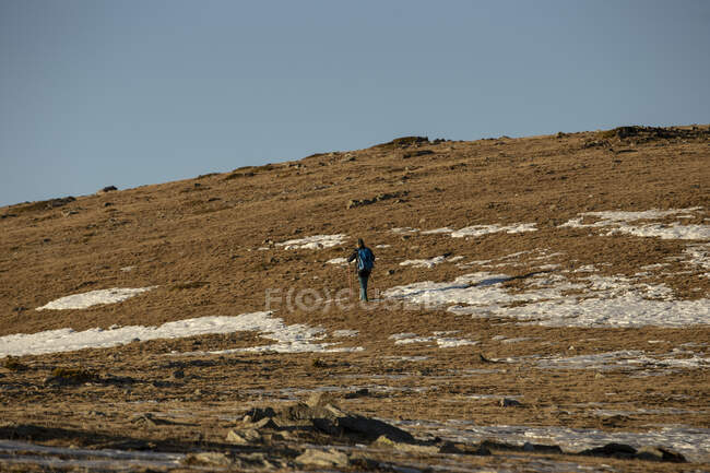 Путешественник с рюкзаком прогуливаясь по сухой долине в горах — стоковое фото