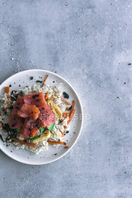 Von oben lecker appetitlich geschnittener Lachs auf weißem Reis mit Gemüse in Teller auf Tisch mit Kopierraum — Stockfoto