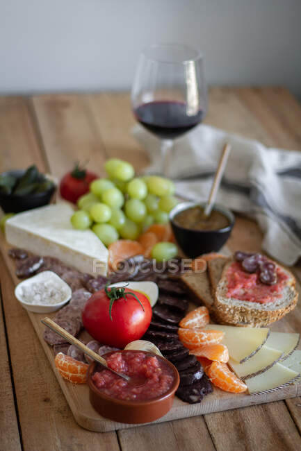 From above of colorful fresh fruits meat vegetables and sauces for wine in hotel — Stock Photo