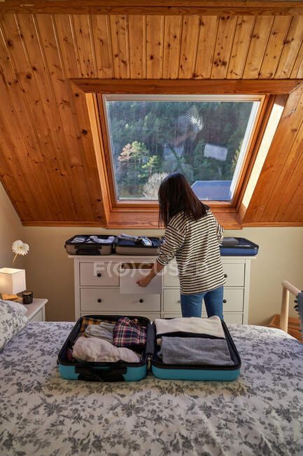 Anonymous woman packing luggage for journey — Stock Photo