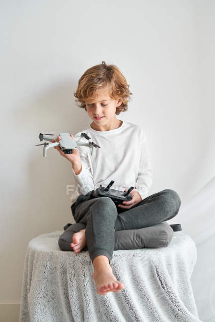 Дитина маніпулює безпілотним літальним апаратом і пультом. — стокове фото