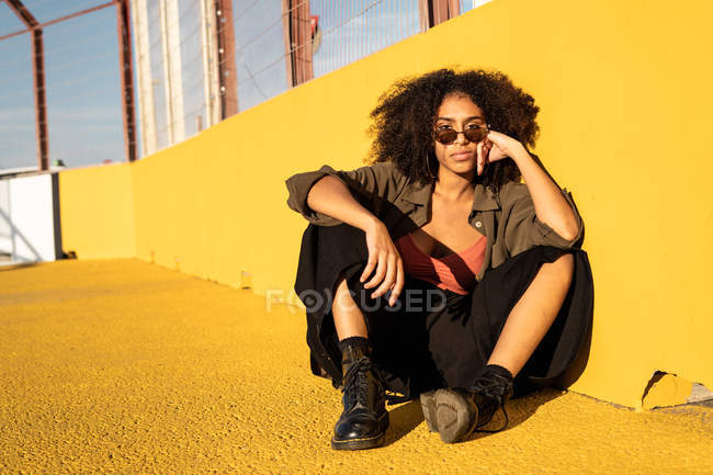 Confident young woman sitting on ground on stadium — Stock Photo