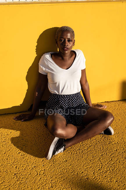 Confident young woman sitting on ground on stadium — Stock Photo