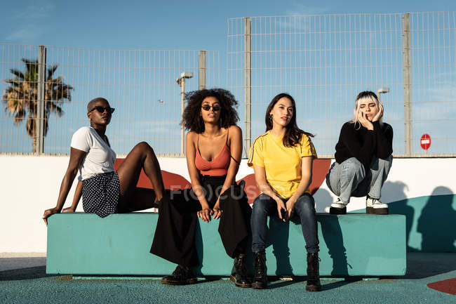 Fröhliche junge multirassische Freundinnen genießen ihre Freizeit auf der Straße — Stockfoto
