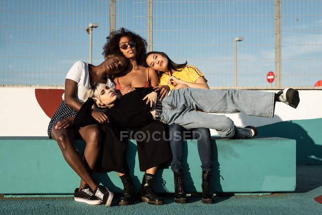 Fröhliche junge multirassische Freundinnen genießen ihre Freizeit auf der Straße — Stockfoto