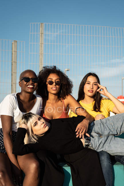 Cheerful young multiracial female friends enjoying free time in street — Stock Photo