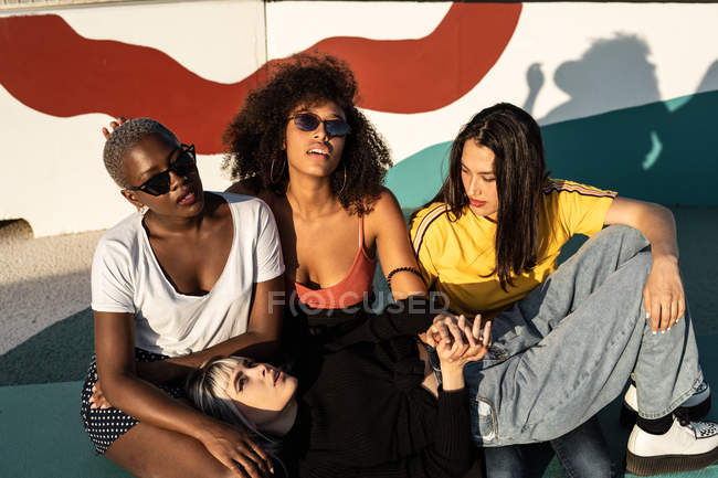 Cheerful young multiracial female friends enjoying free time in street — Stock Photo