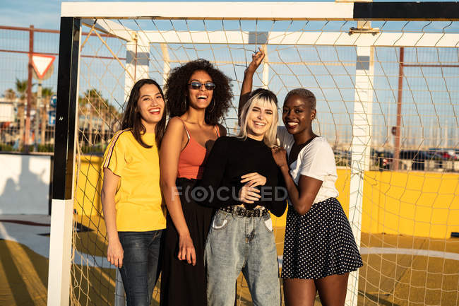 Fokussierte junge multirassische Freundinnen verbringen ihre Freizeit gemeinsam im Stadion — Stockfoto