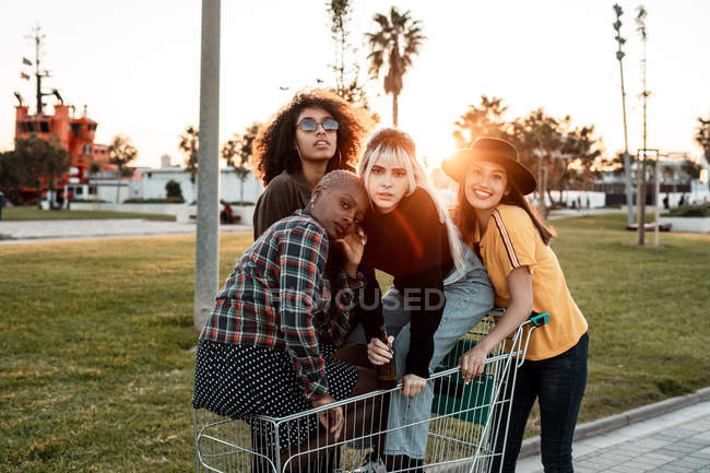 Мультирасова група молодих жінок, що стоять по дорозі за покупками. — стокове фото