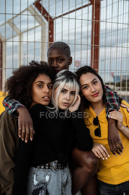Різноманітна група усміхнених жінок, що обіймаються разом на газоні — стокове фото