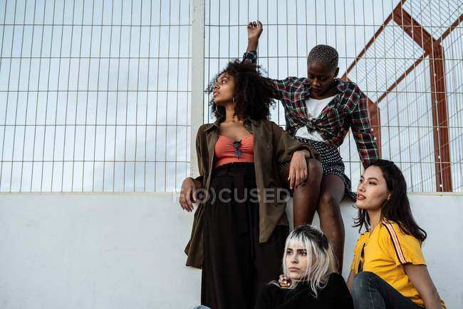 Ethnic young women in casual clothes looking away with fearless eyes — Stock Photo