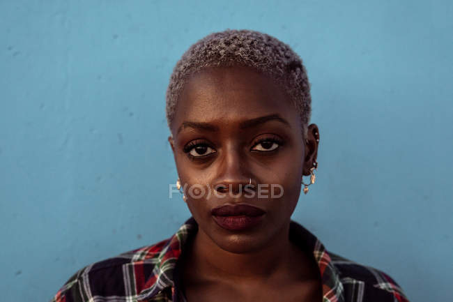 Молода чорношкіра короткошерста жінка дивиться на камеру з інтенсивним виглядом — стокове фото