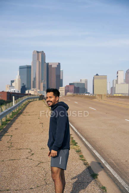 Jovem atleta masculino hispânico de pé na berma da estrada no centro de Dallas, Texas — Fotografia de Stock