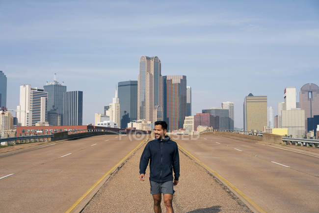 Молодой латиноамериканец, идущий по обочине дороги в центре Далласа, штат Техас — стоковое фото