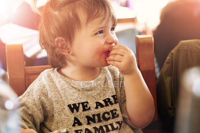 Bébé fille assis et manger — Photo de stock