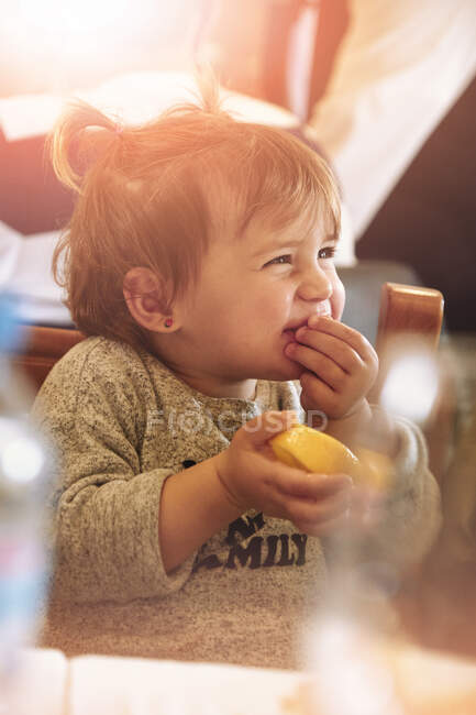 Baby girl sitting and eating — Stock Photo