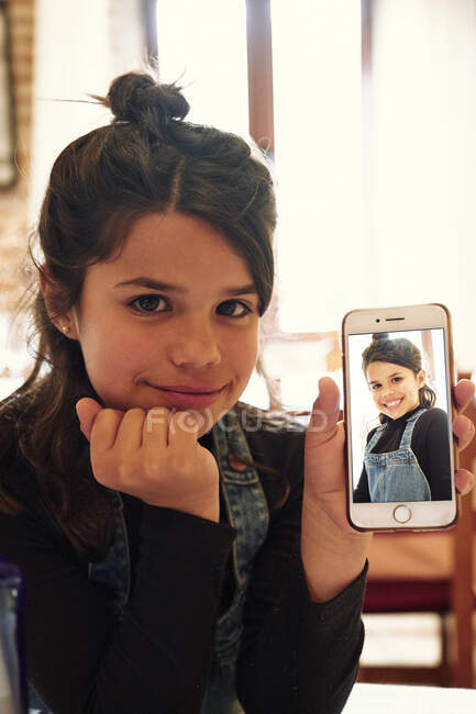 Content casual girl demonstrating self photo on smartphone — Stock Photo