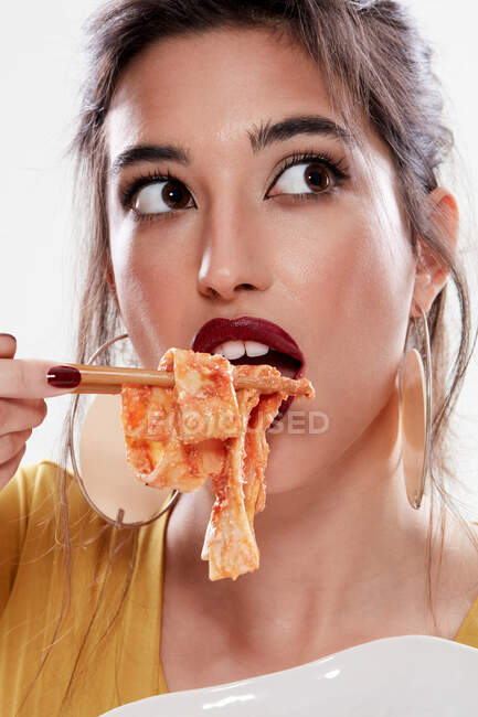 Элегантные брюнетки открывают рот и используют палочки для еды — стоковое фото
