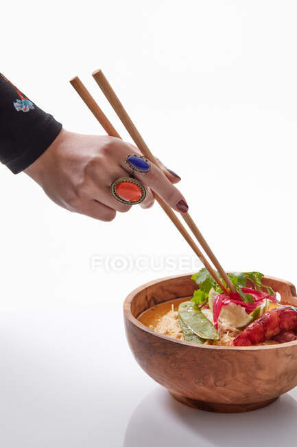 Anonymous fashionable woman with chopstick and Asian dish — Stock Photo