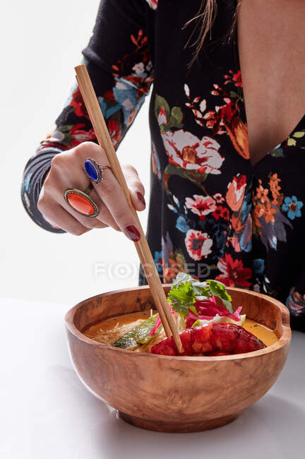 Donna alla moda anonima con bacchetta e piatto asiatico — Foto stock
